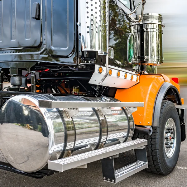 Un grand camion semi-remorque avec un réservoir imposant à l'arrière, équipé de marchepieds pour un accès facile.