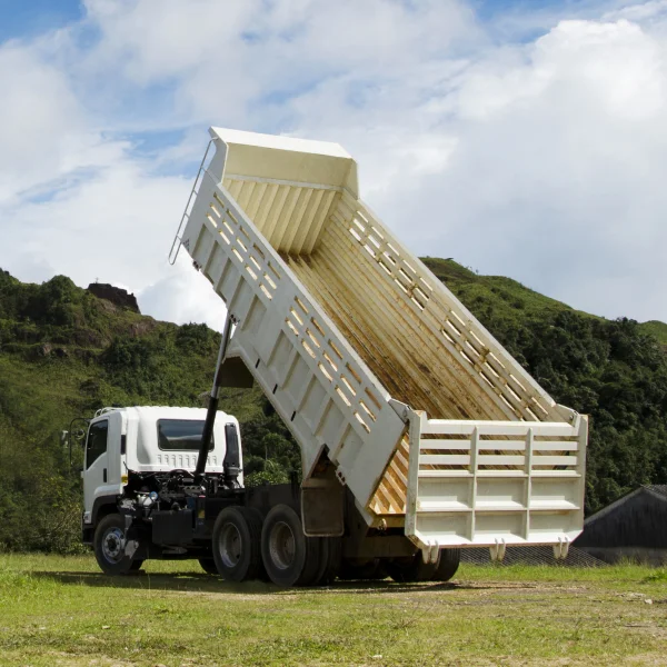 Camion blanc avec une grande benne basculante, prêt à transporter des matériaux.
