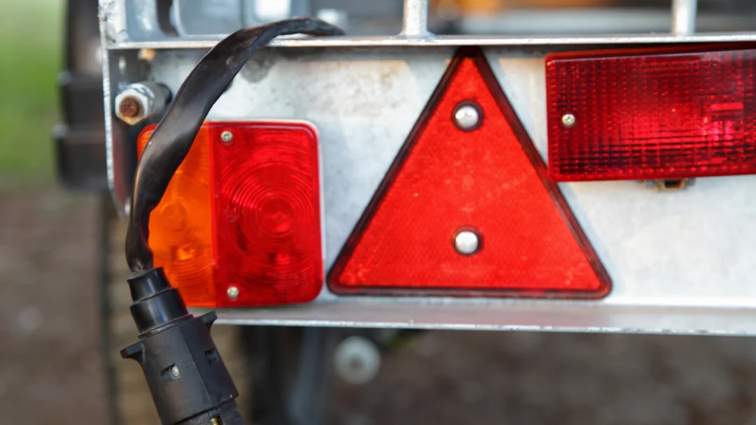 Gros plan sur une remorque avec un triangle rouge et un pare-choc visible, mettant en avant les détails de l'équipement.